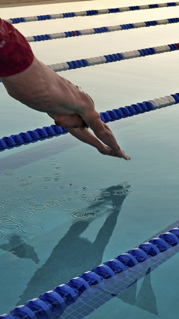 A man dives into a lap pool