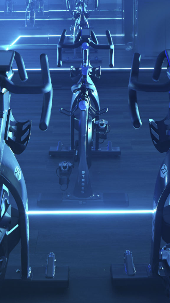 Cycle studio lit with blue lights located at the Life Time Frisco club locaton