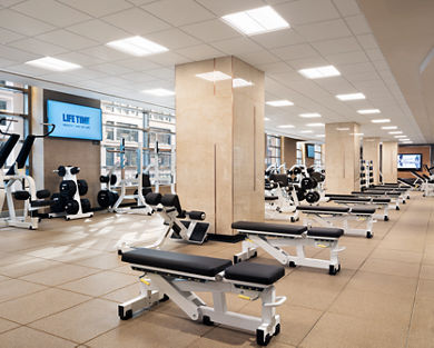 Fitness floor filled with benches and free weights at Life Time