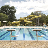 Outdoor lap pool with lane lines and a large waterslide at Life Time