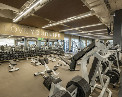 Free weights and strength training machines on the fitness floor at Life Time