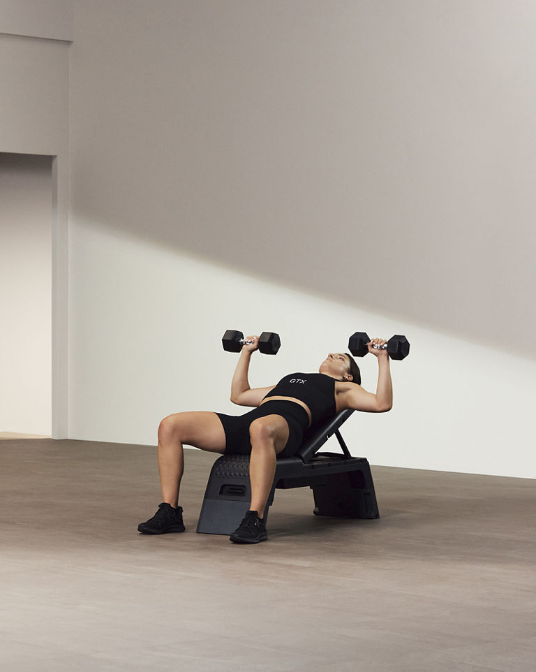 A Life Time GTX instructor demonstrating a bench press