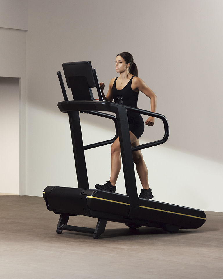 A Life Time GTX instructor demonstrating incline walk on a treadmill