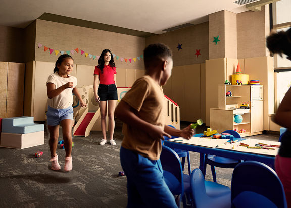 kids playing in a room with blue chairs