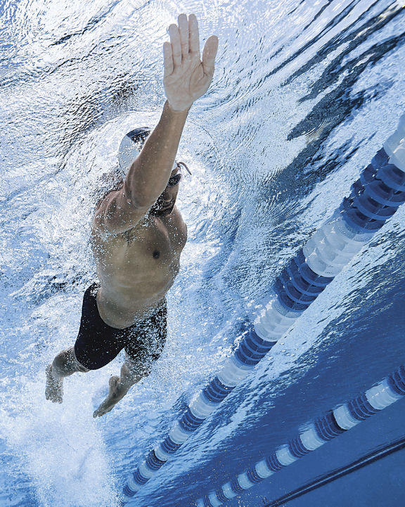 Underwater view of a man swimming in an indoor lap pool