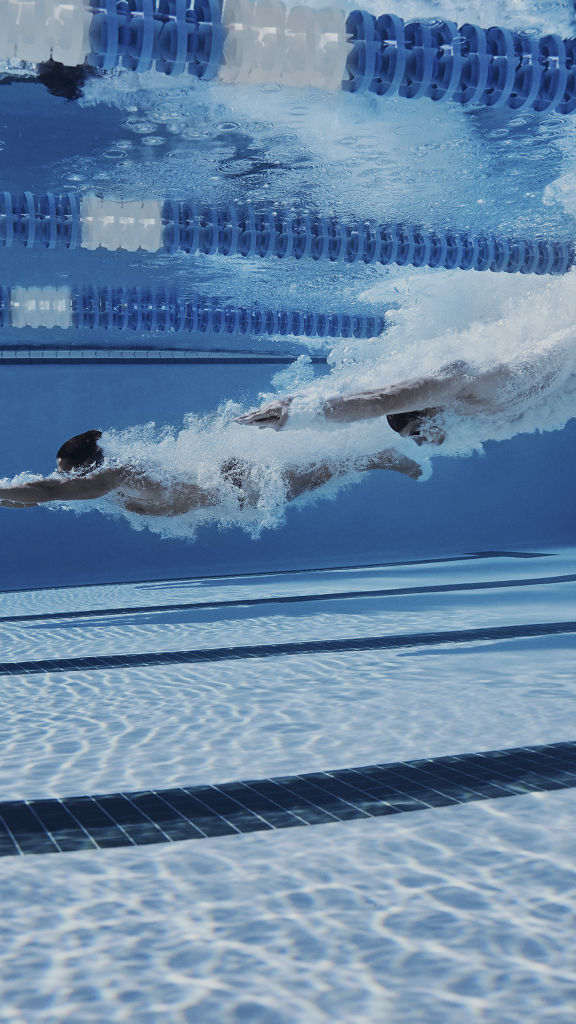 Underwater view of a man swimming in an indoor lap pool