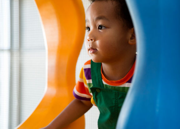 Close view of a male child playing on an indoor playground