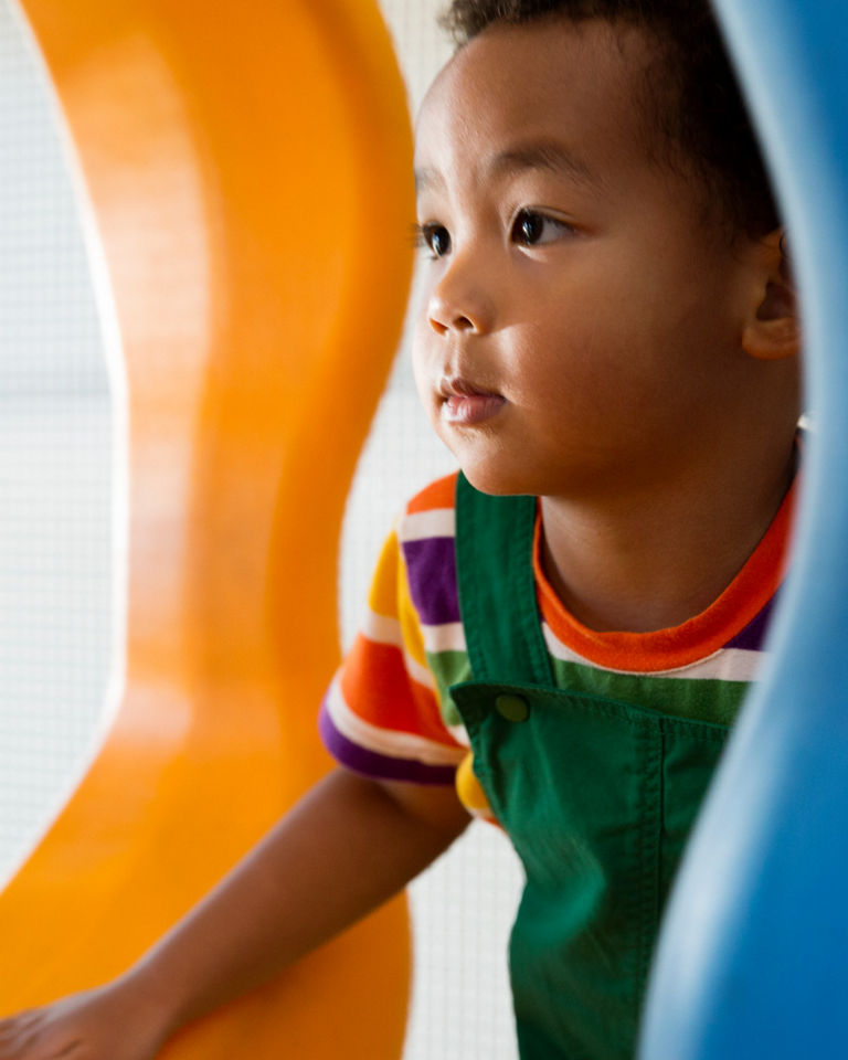 Close view of a male child playing on an indoor playground