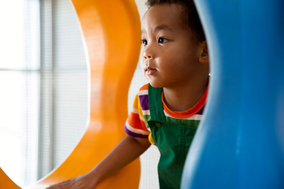 Close view of a male child playing on an indoor playground