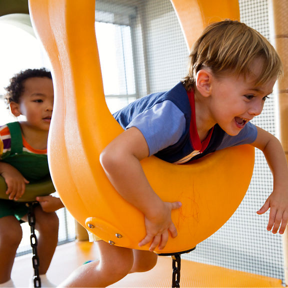 Two male children playing on an indoor playground