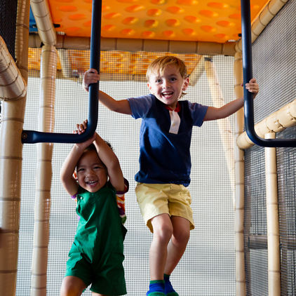 Two male children playing on an indoor playground