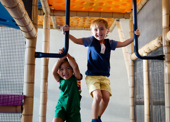 Two male children playing on an indoor playground