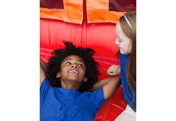 two kids laying on an inflatable bounce house