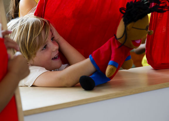 A male child playing with a puppet at Life Time Kids Academy