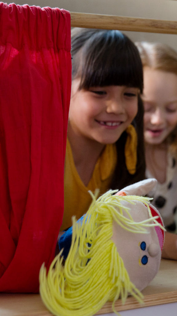 Three children playing with puppets at Life Time Kids Academy