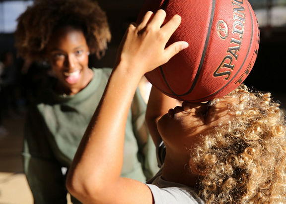 A young child holding a basketball above their head