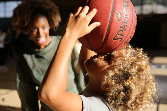 A young child holding a basketball above their head