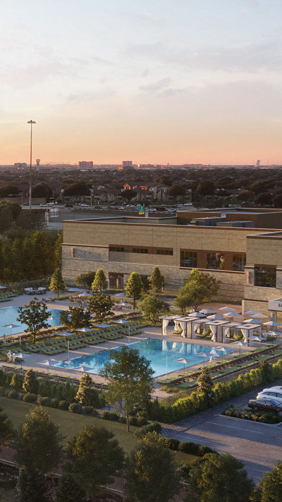 An aerial view of the exterior of Life Time Las Colinas at dusk
