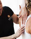 A LifeClinic chiropractor touching and examining a female clients spine