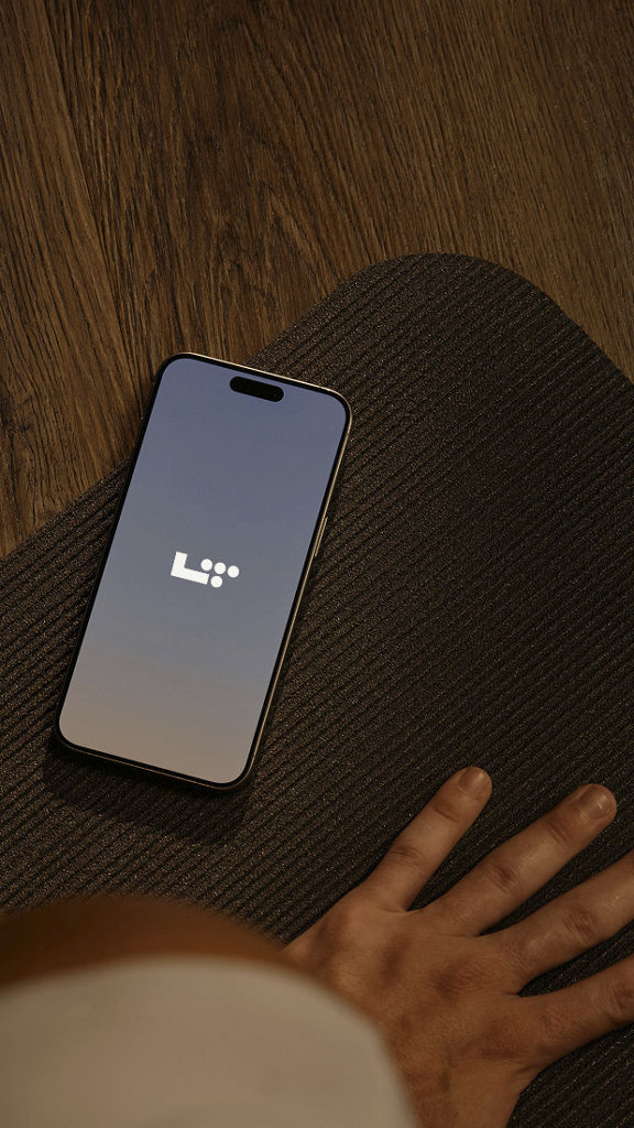 phone displaying L T app on a yoga mat