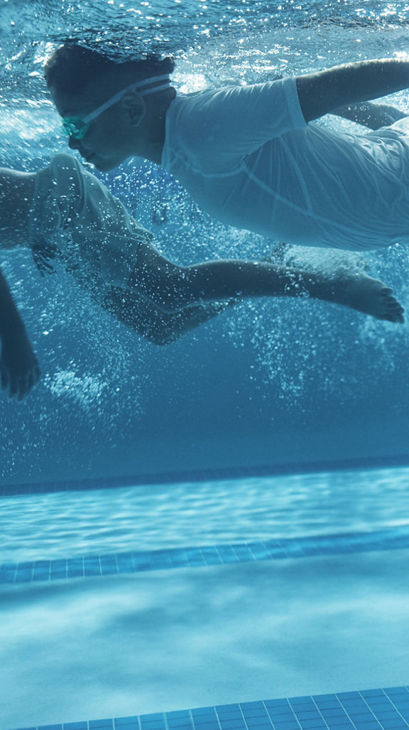 two boys swimming under water