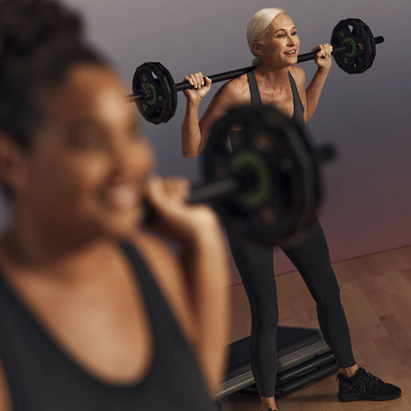 Life Time member squatting with a barbell during a Lift strength class