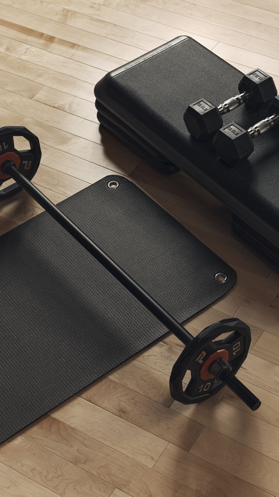 Barbell across a matt with dumbbells on step platform for the Lift strength class