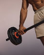 Stylized image of a shirtless Life Time member holding a barbell in a Lift strength class