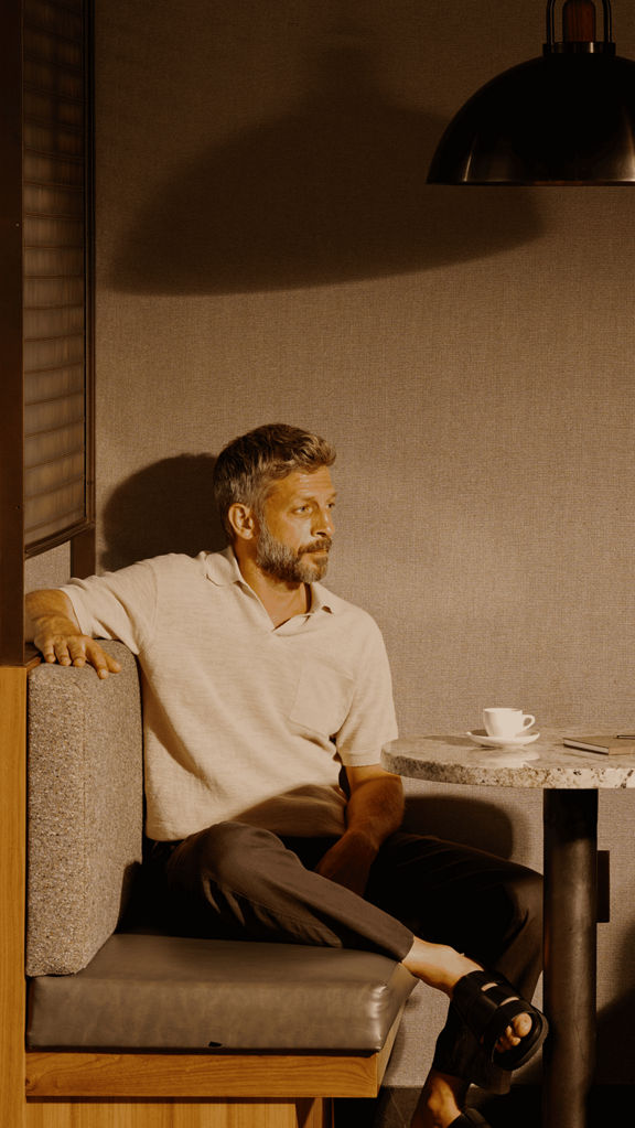 A man sitting in a booth with a coffee