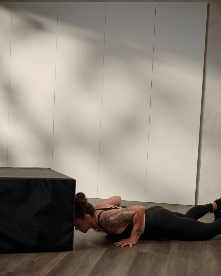 a woman doing a burpee and box jump
