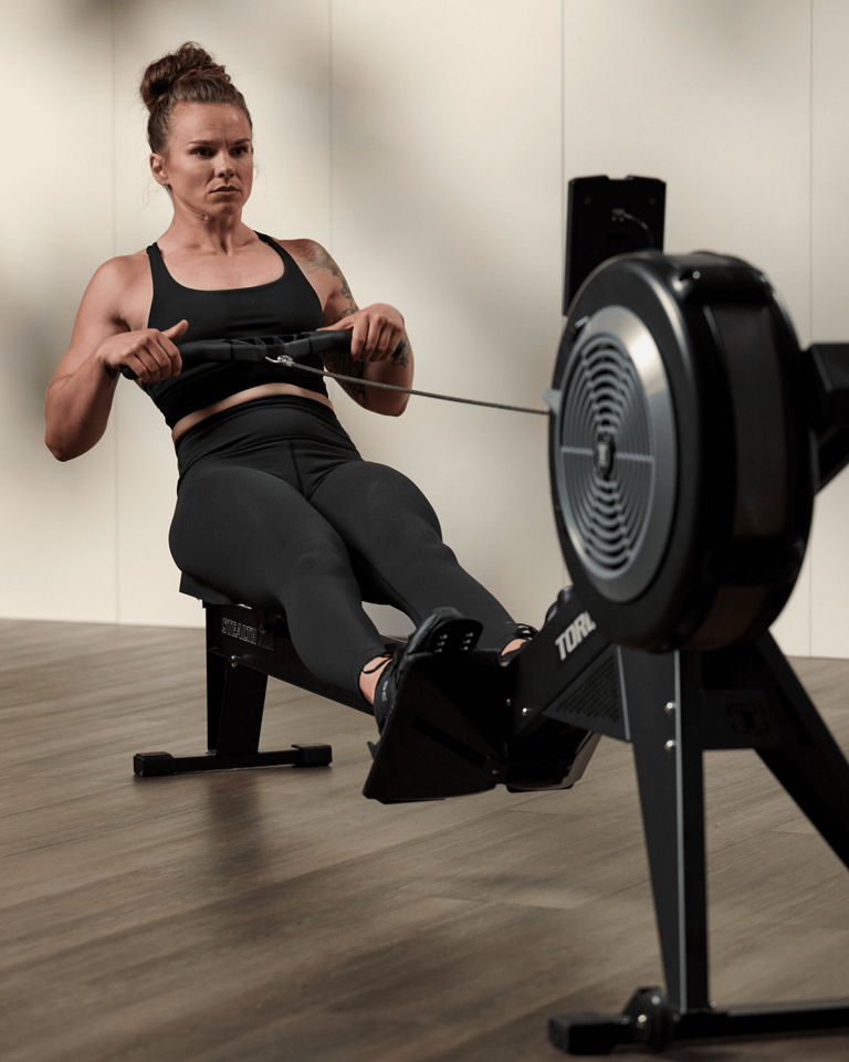 a woman using a row machine
