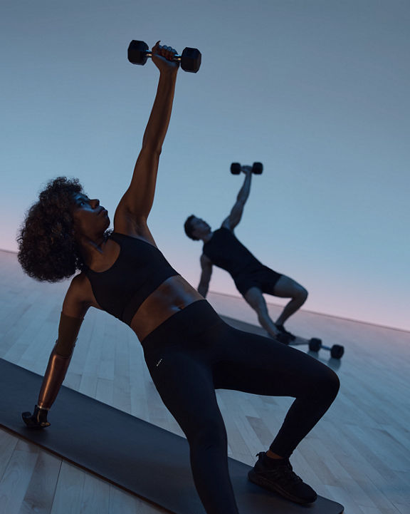 Maxout strength class featuring people in a floor pose with a dumbbell held overhead