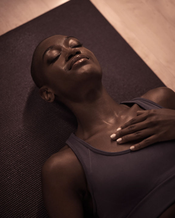 Life Time member laying on their mat at the end of a MB360 boutique group training class