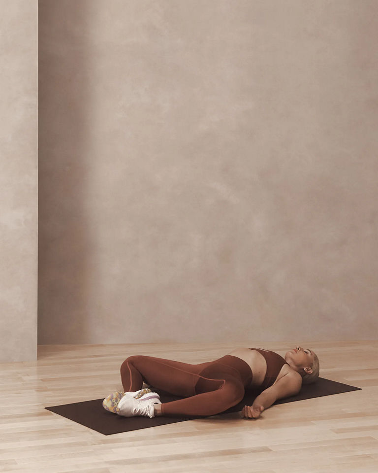 a woman laying in supine butterfly pose