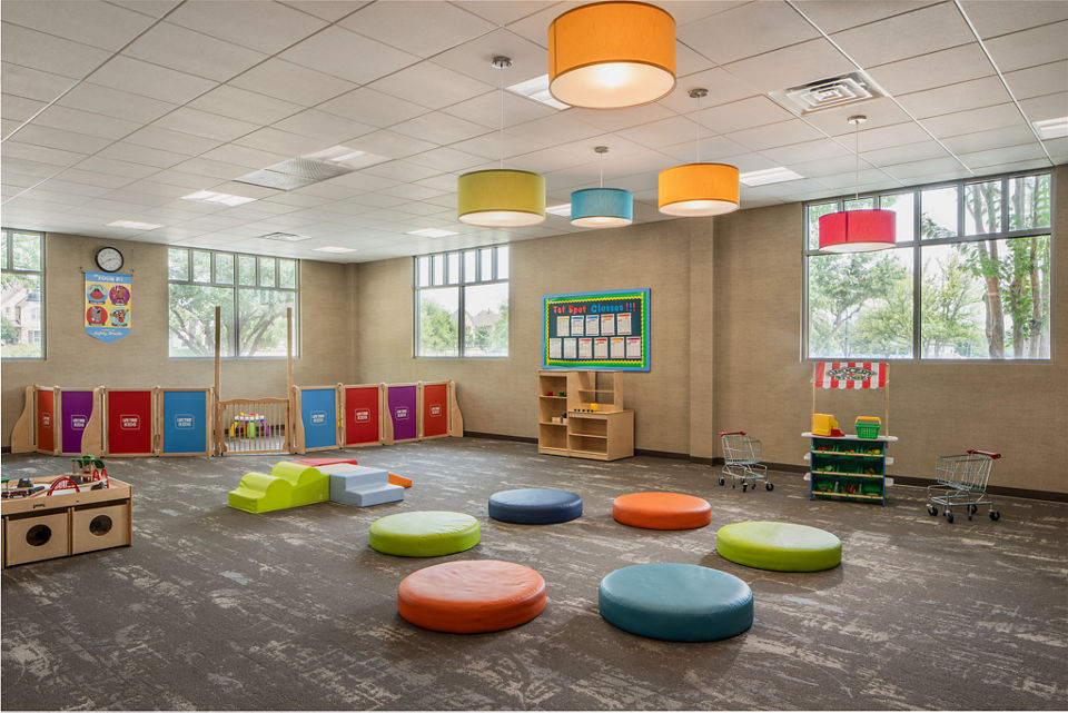 A colorful child care area with toys and foam seating