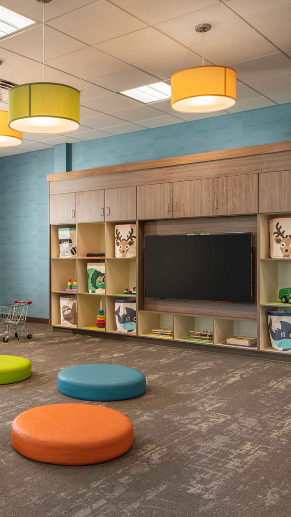 Toddler area with colorful seating pads and toys in a Life Time Child Center