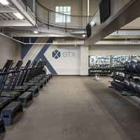 A row of treadmills, kettlebells, and medicine balls in a GTX training area