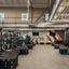 An Alpha training area with plyometric boxes, squat racks, and treadmills