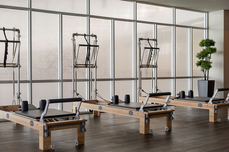 3 pilates reformers in brightly lit pilates fitness room