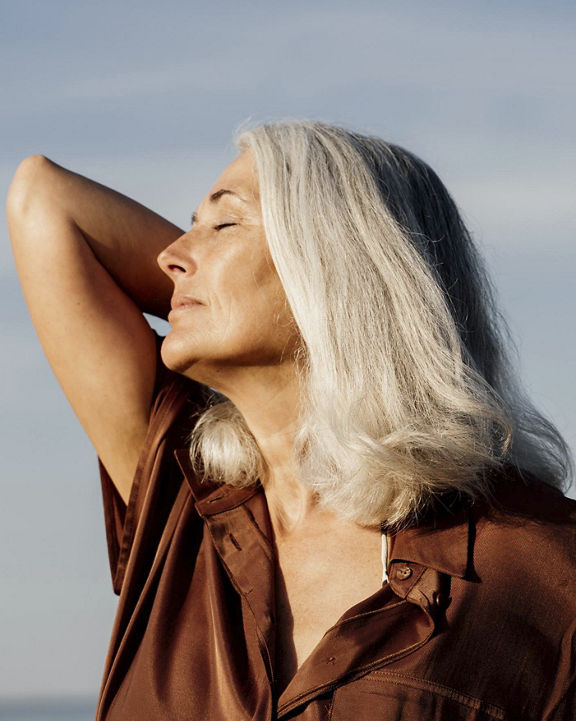 a woman stretching towards the sun