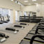 Treadmills, dumbbells and yoga mats laid out in a workout area