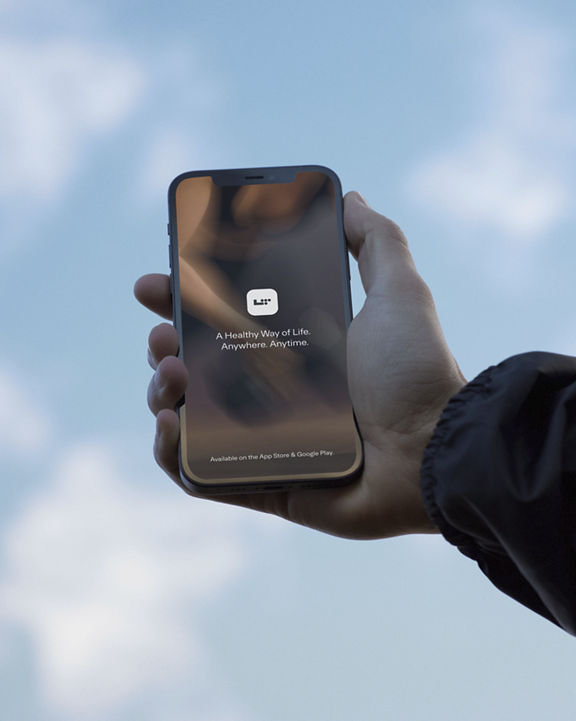 A hand holding a phone with a blue sky in the background