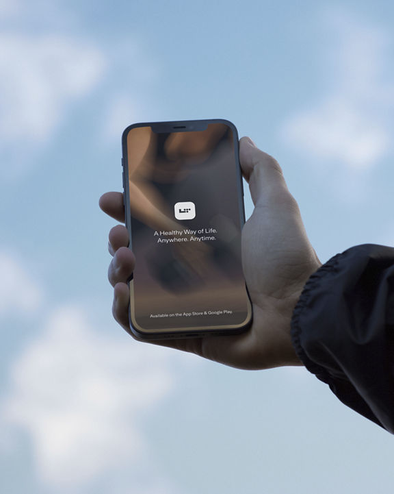 A hand holding a phone with a blue sky in the background