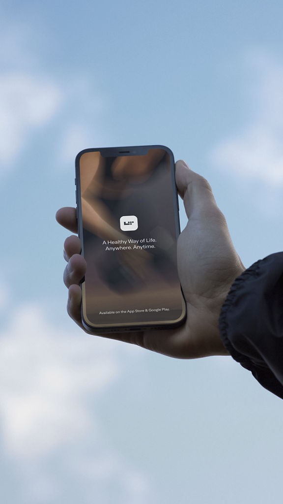 A hand holding a phone with a blue sky in the background