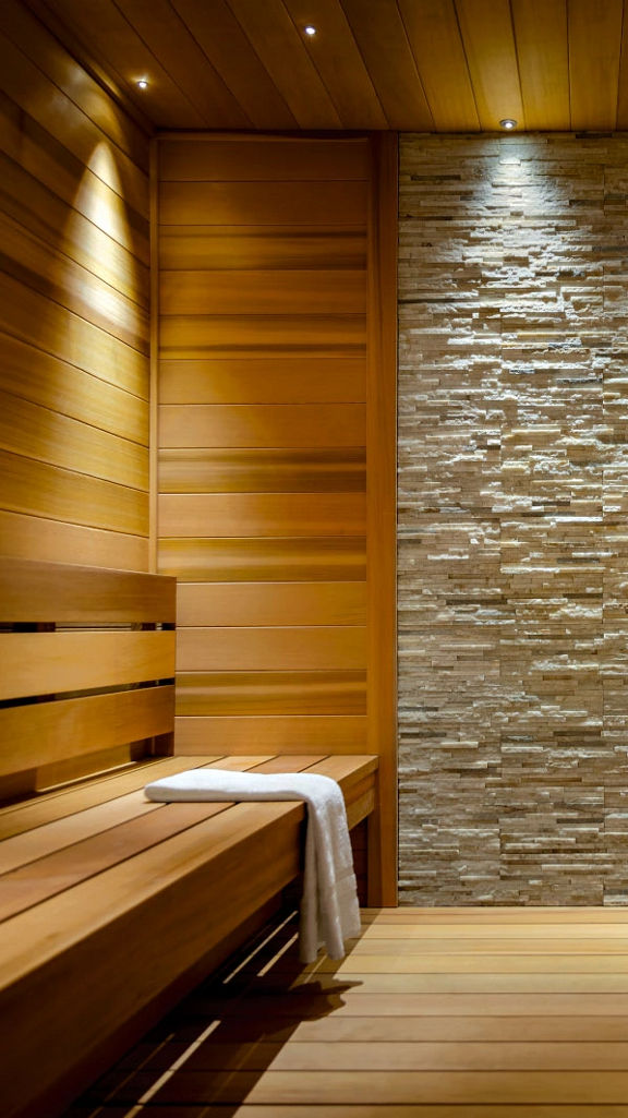 Brightly lit wooden and tiled sauna at Life Time