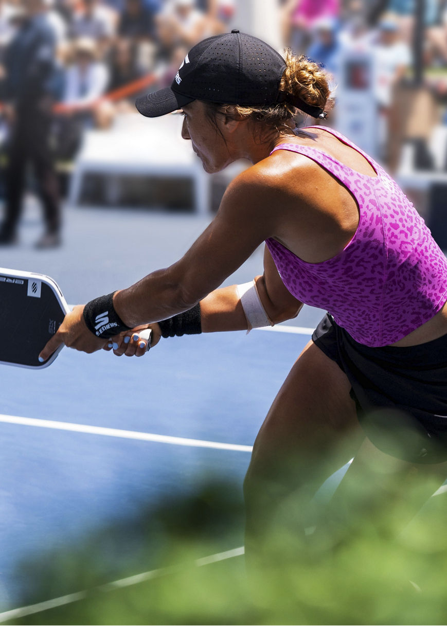 woman hitting a pickleball