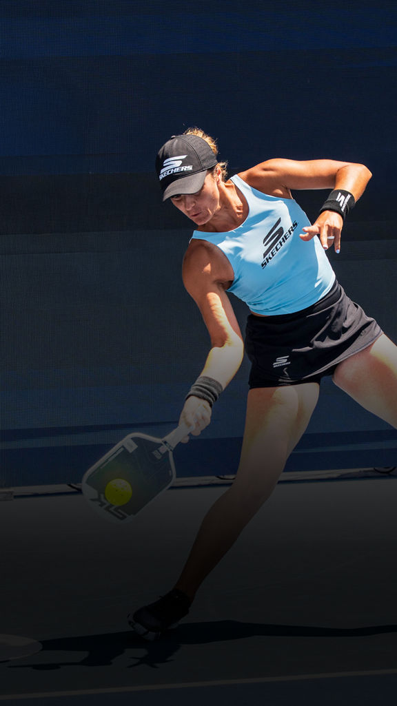 woman hitting a pickleball with a paddle