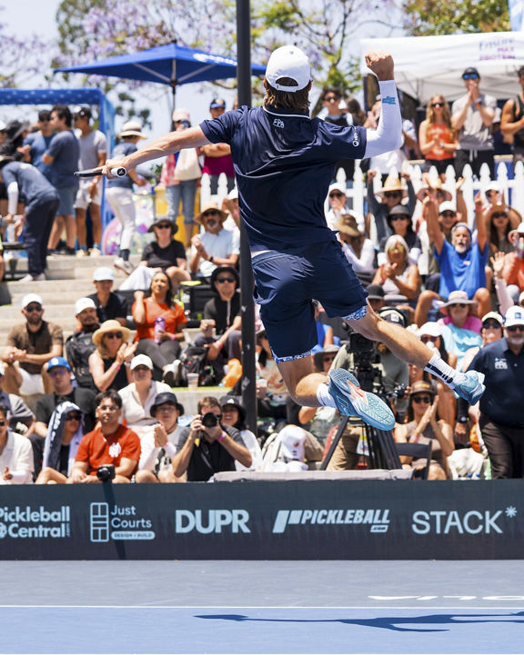 man jumping up in the air to hit a pickleball
