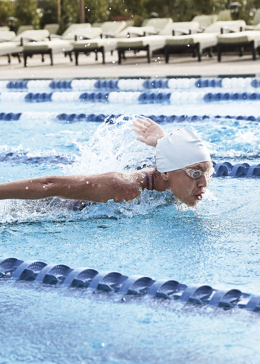 People swimming laps in an outdoor pool at Life Time