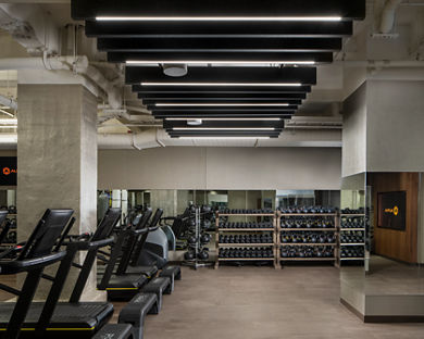 Fitness floor filled with treadmills, dumbbells and kettlebells on racks